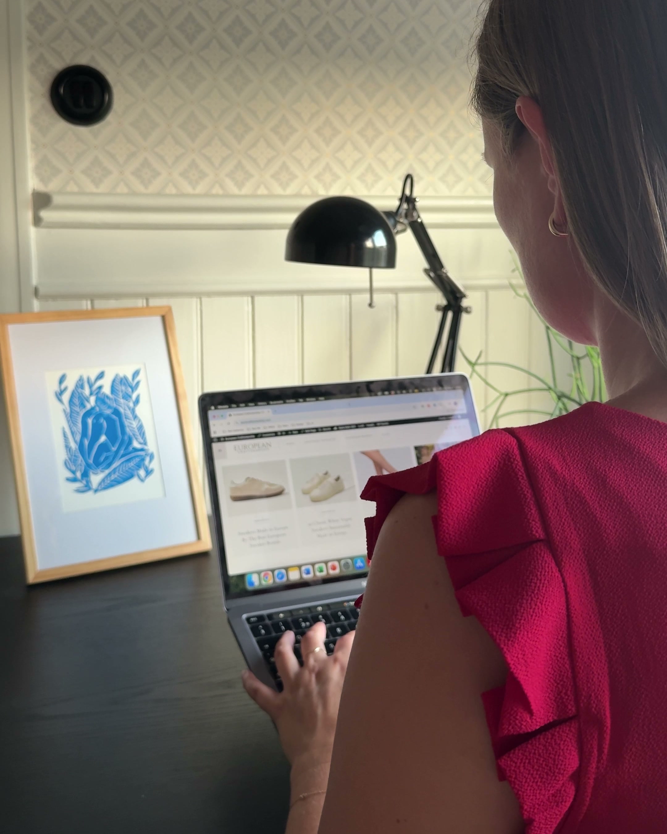Lisa at her desk, pointing at sneaker product pages on a laptop screen